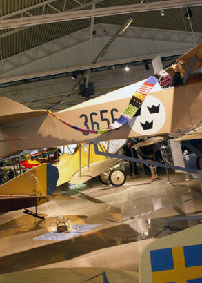 En l&aring;ng stickad halsduk olika f&auml;rger, s&aring; kallad stickgraffitti, h&auml;nger &ouml;ver n&aring;gra flygplan i en av utst&auml;llningshallarna.