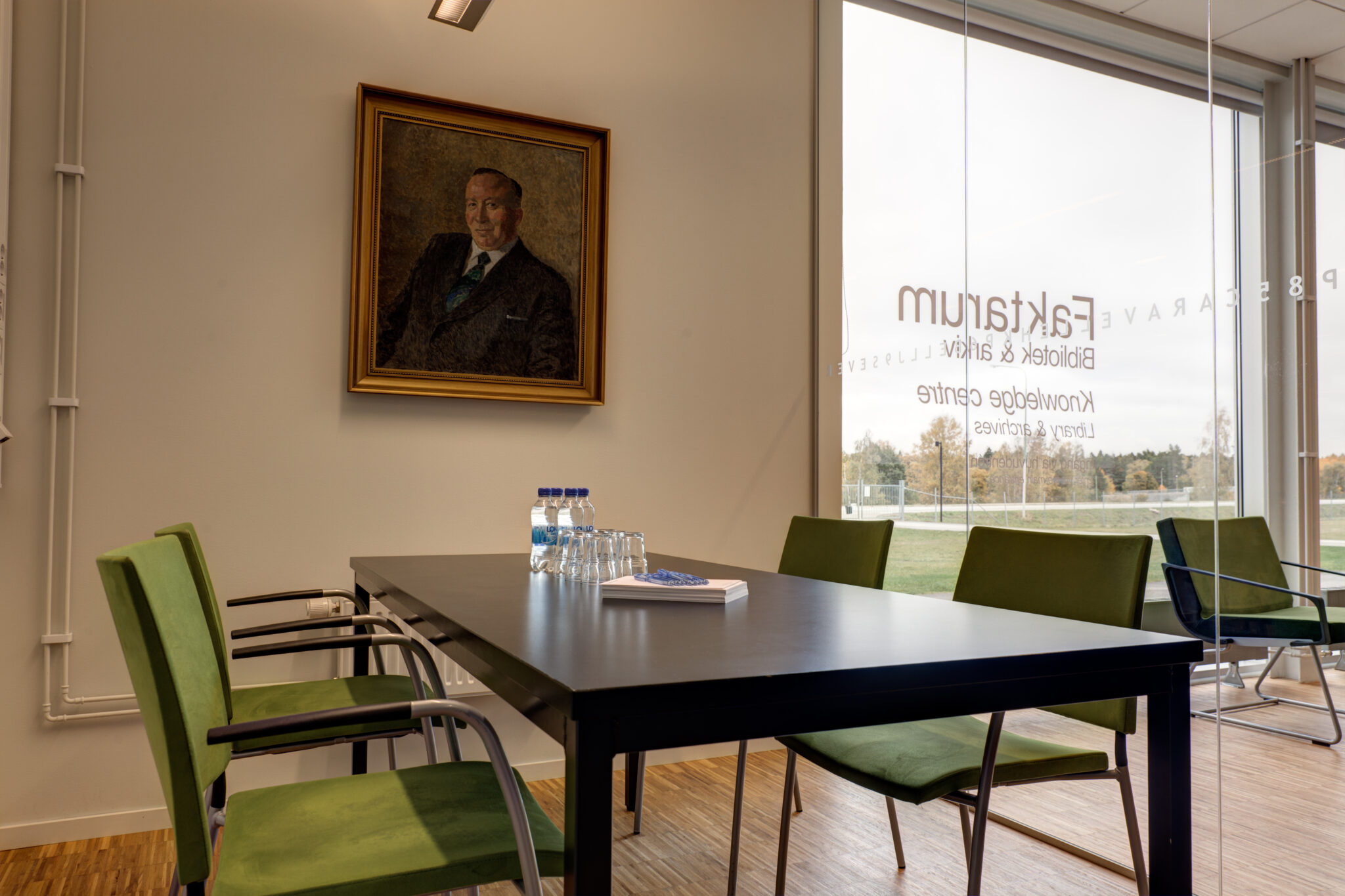 Heinerstamrummet &auml;r ett litet grupprum med ett bord och fyra stolar och mycket ljusinsl&auml;pp. P&aring; v&auml;ggen h&auml;nger ett portr&auml;tt av en man.