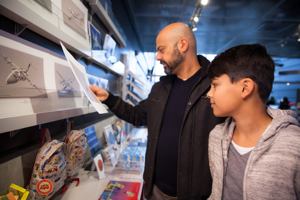 Två besökare kollar in utbudet i Flygvapenmuseums butik.
