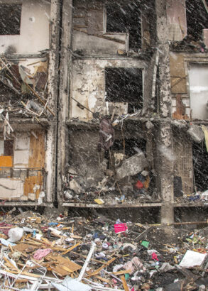 Ett krigsh&auml;rjat flerfamiljshus med gapande h&aring;l d&auml;r f&ouml;nster tidigare har suttit och massa skr&auml;p och husdelar p&aring; marken framf&ouml;r.