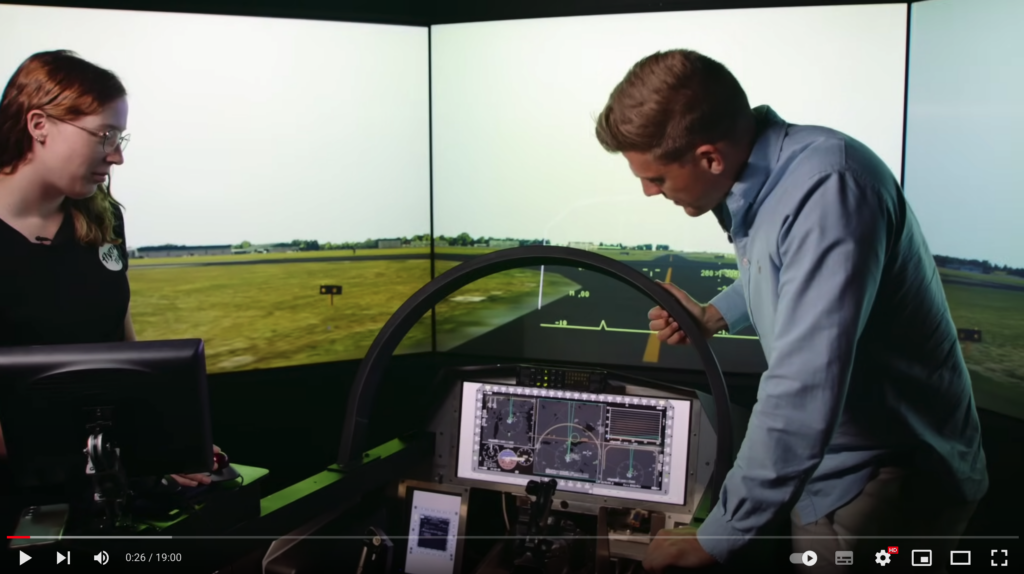 Youtubern Max Willman förbereder sig för flygning av flygsimulatorn. En av museets medarbetare står bredvid och kollar på.