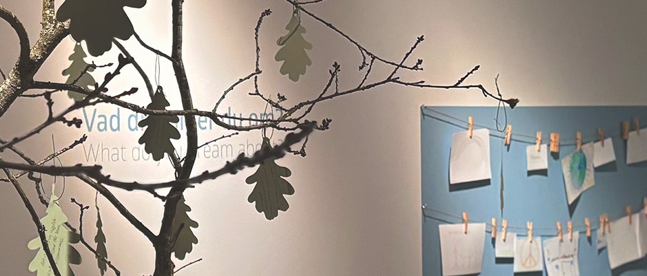 En del av en utst&auml;llning med texter p&aring; l&ouml;v och barns teckningar om fred.